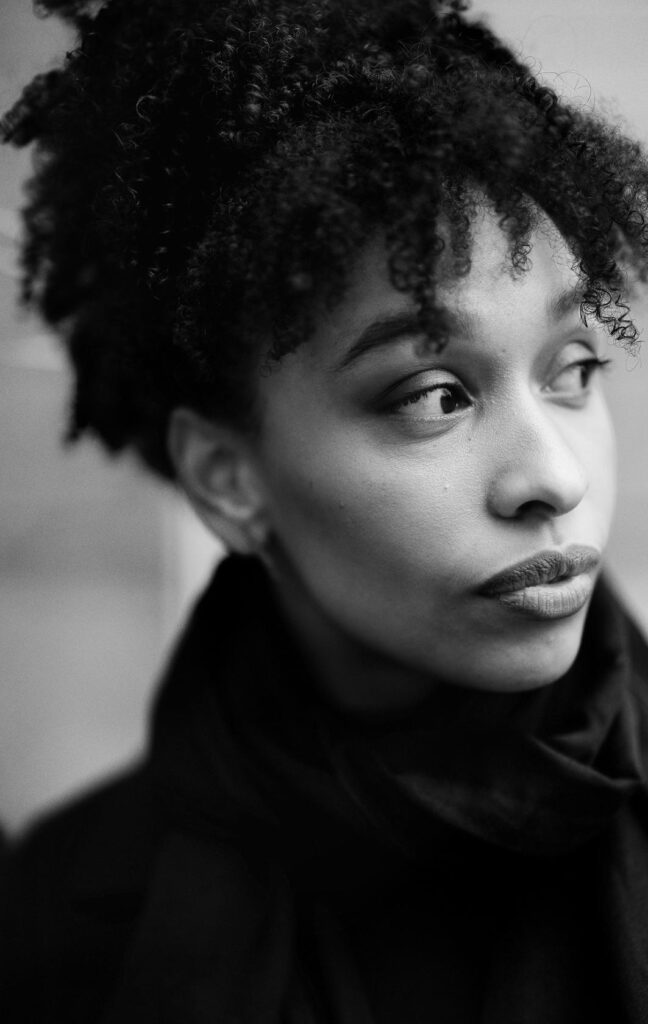 A black-and-white picture of Esohe Weyden looking past the camera. Een zwart-witfoto van Esohe Weyden die langs de camera kijkt.
