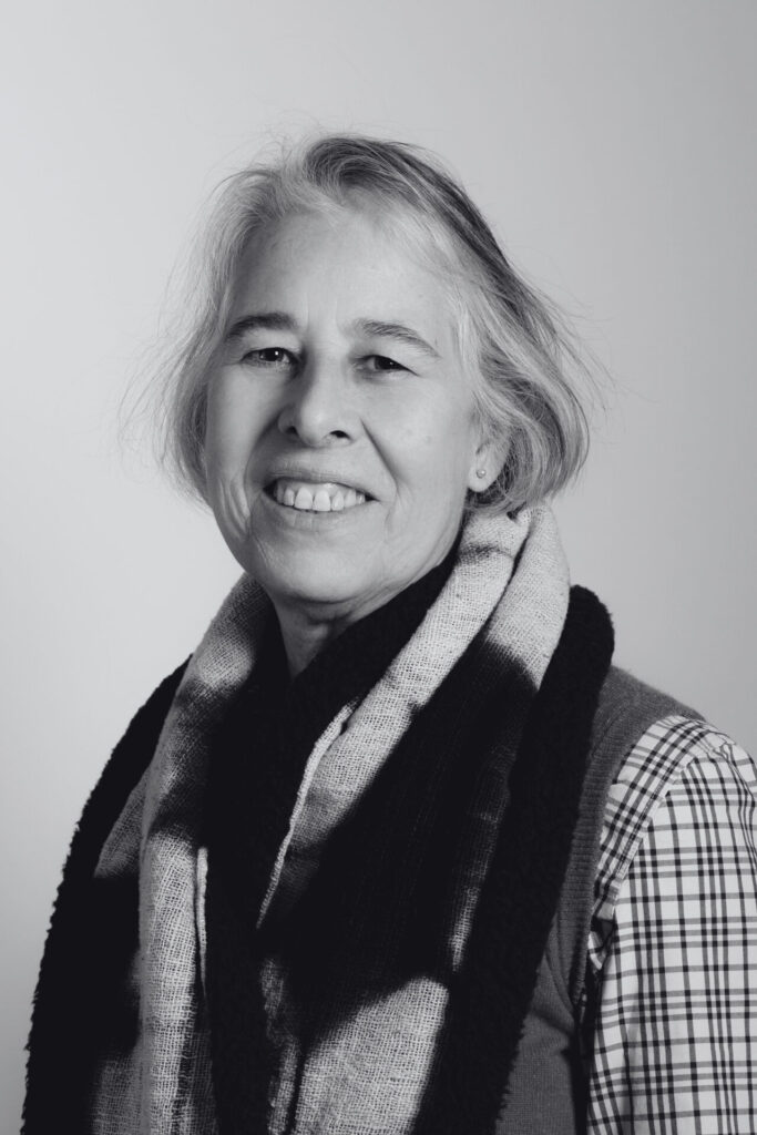 A black-and-white portrait of Emily Andersen smiling at the camera. Een zwart-witportret van Emily Andersen die naar de camera lacht.