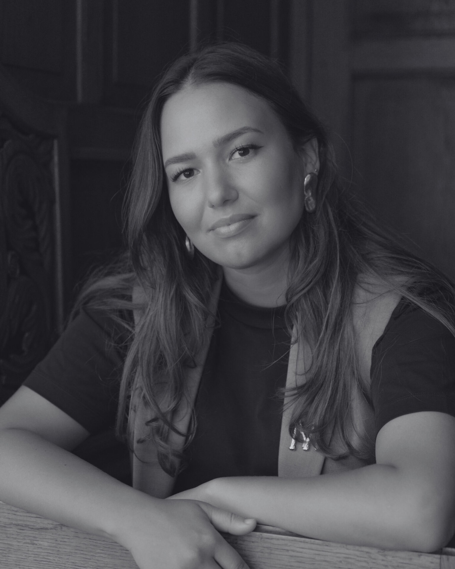 A black-and-white picture of Myriem El Kaddouri smiling at the camera. Een zwart-witfoto van Myriem el Kaddouri die naar een camera glimlacht.