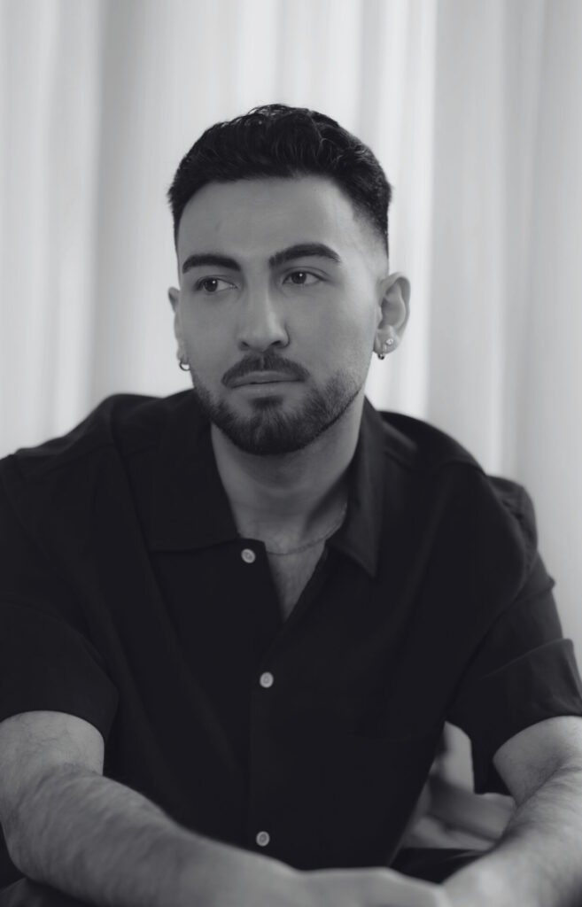 A black-and-white picture of Hasan Gök looking past the camera. Een zwart-witfoto van Hasan Gök die langs de camera kijkt.