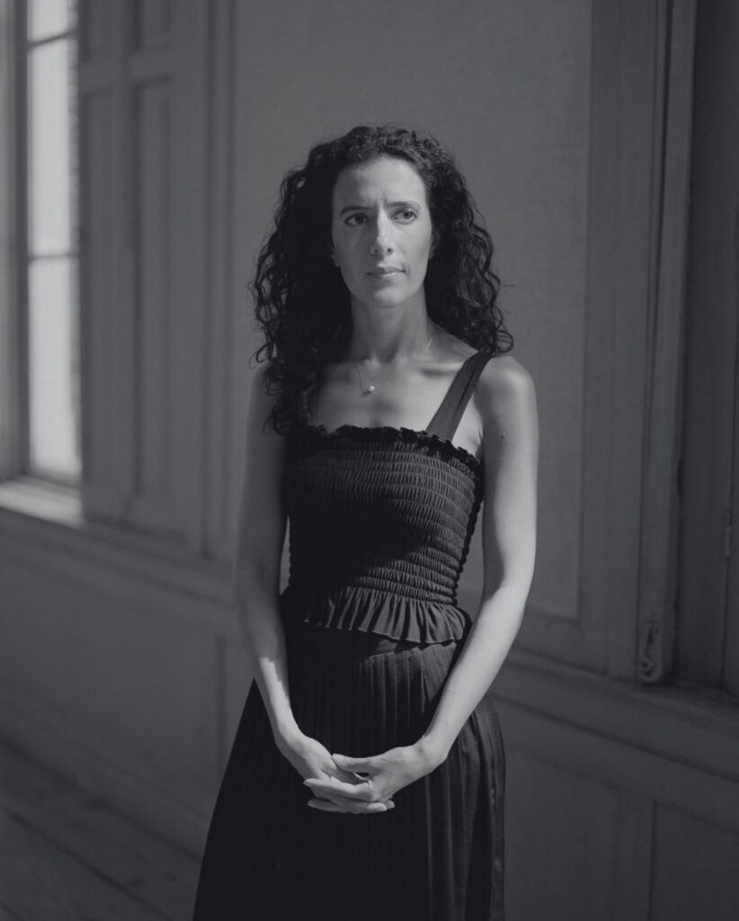 A black-and-white portrait of Yousra Benfquih looking slightly away from the camera. Een zwart-witportret van Yousra Benfquih die net langs de camera kijkt.