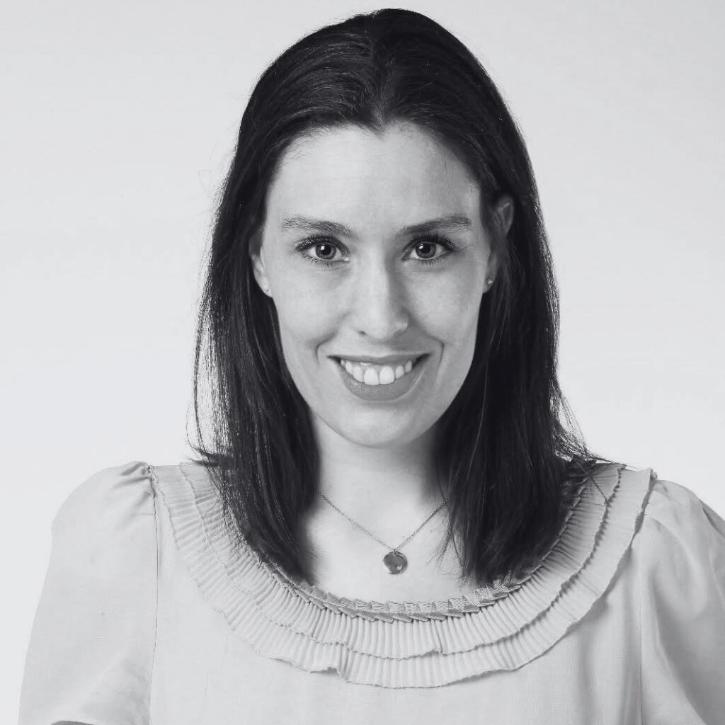 A black-and-white picture of Sophie Reinders smiling at the camera. Een zwart-witfoto van Sophie Reinders die naar de camera lacht.