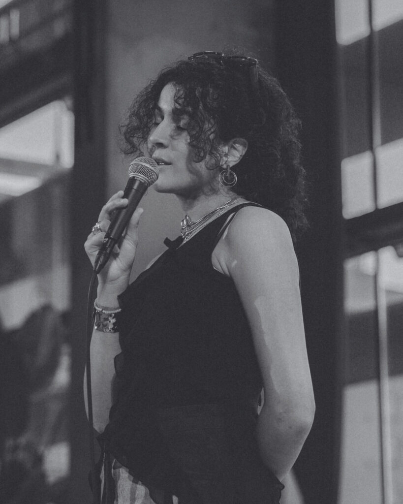 A black-and-white picture of Anissa El Mazouzi performing. Een zwart-witfoto van Anissa El Mazouzi die optreedt.