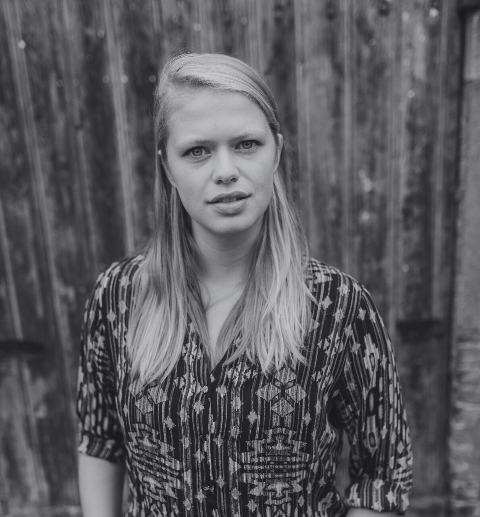 A black-and-white picture of Lotte Lentes looking at the camera. Een zwart-witfoto van Lotte Lentes die naar de camera kijkt.
