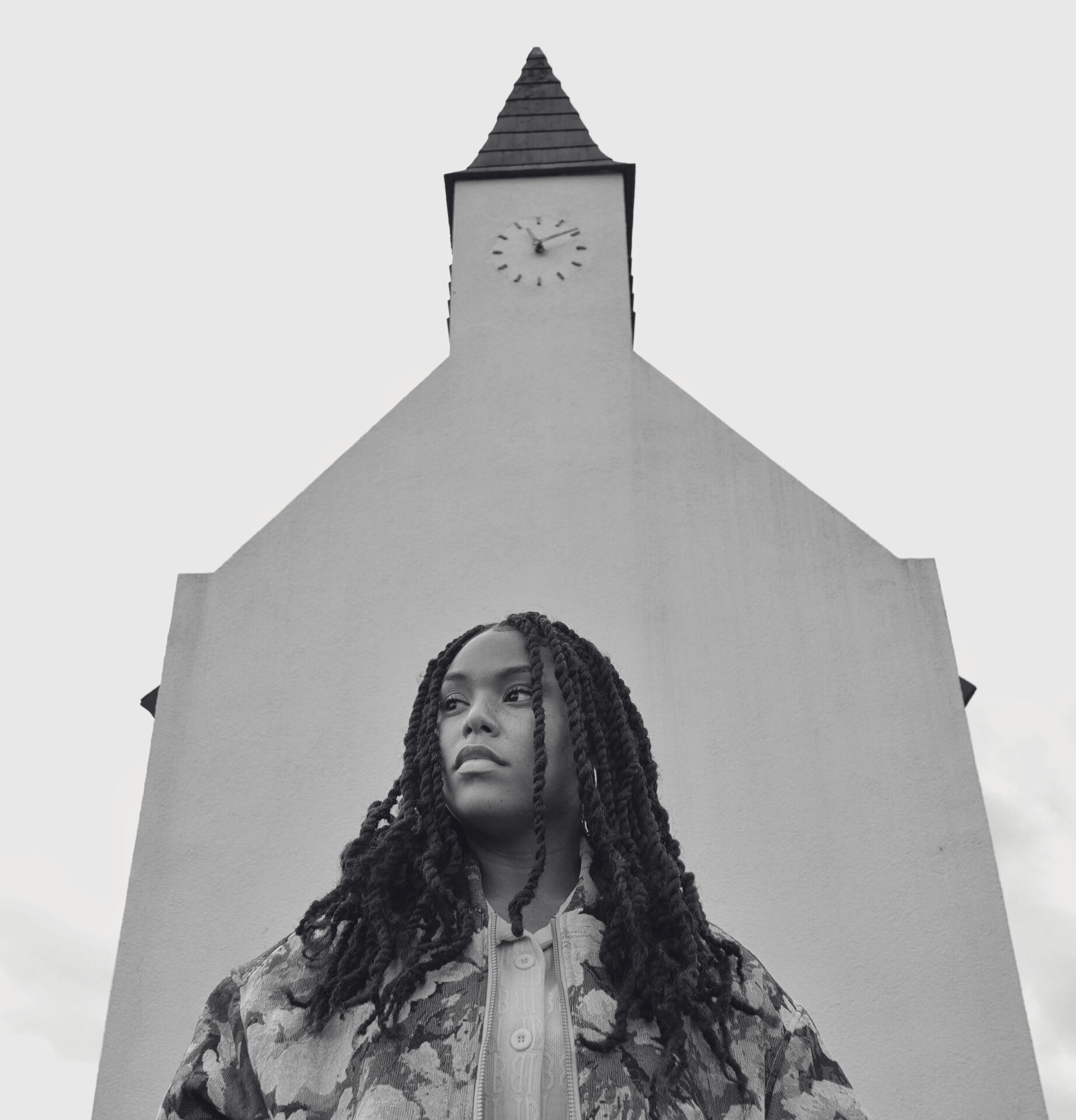 A black-and-white picture of SHERR in front of a building. Een zwart-witfoto van SHERR voor een gebouw.