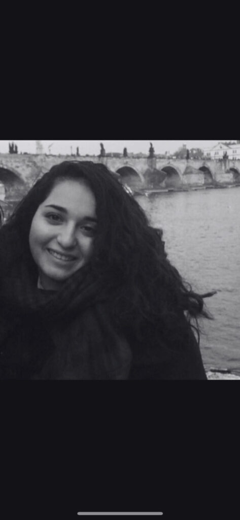 A black-and-white picture of Lina Al-Hassany in front of a bridge. Een zwart-witfoto van Lina Al-Hassany voor een brug.