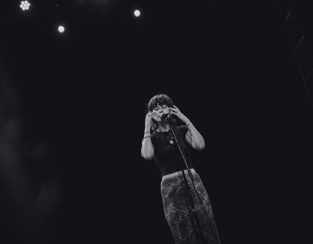 A black-and-white picture of Liya Noa performing on stage. Een zwart-witfoto van Liya Noa die op het podium optreedt.